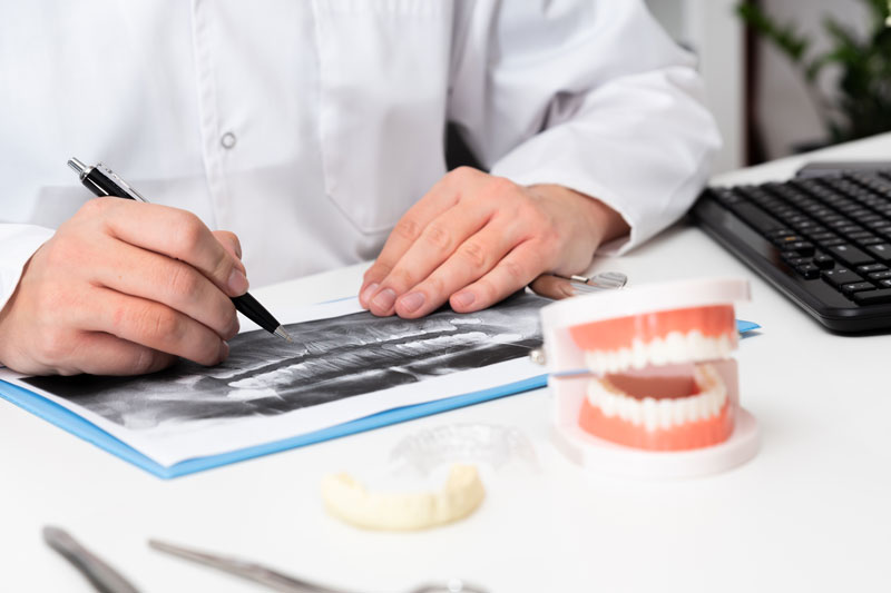 a dentist going over the weaknesses in the teeth with a model close by